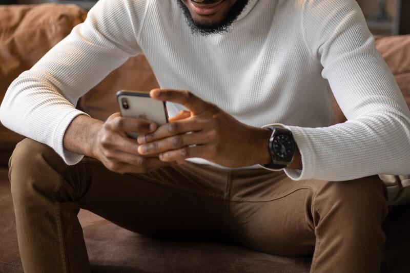How to Send a Blank Text Message on Your Phone Sitted man texting on an iPhone