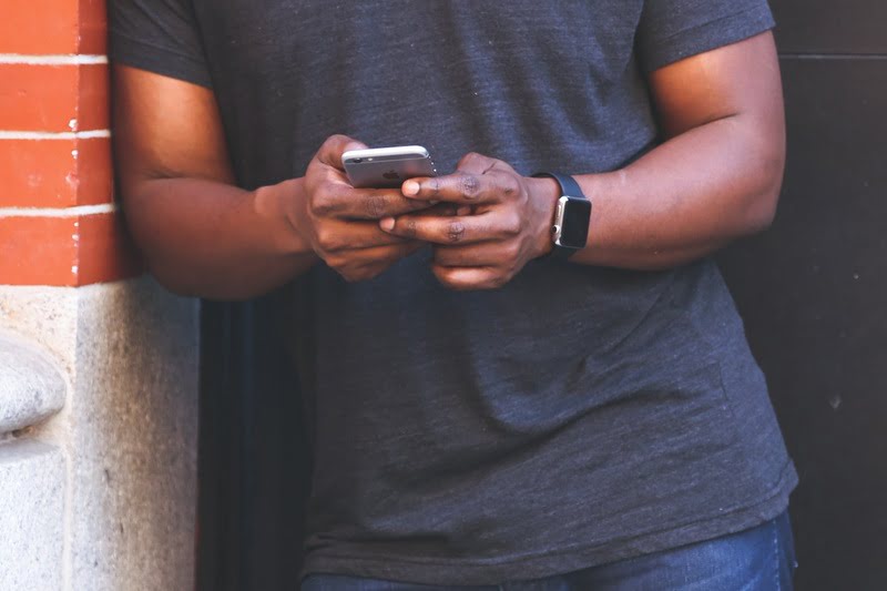 How to Check Your Safaricom Tunukiwa Balance Man using an iPhone while standing