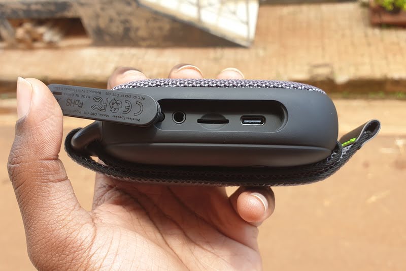 Man holding a portable Bluetooth speaker