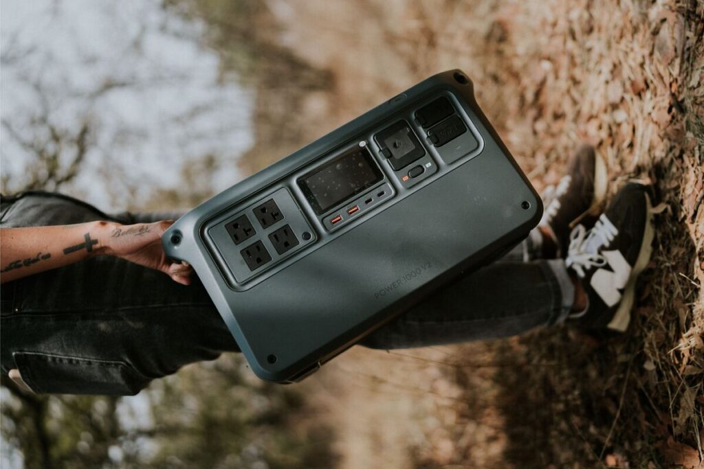 7 Best Heavy-Duty Power Stations for Blackouts, Camping & Off-Grid Living Man carrying a portable power station outdoors